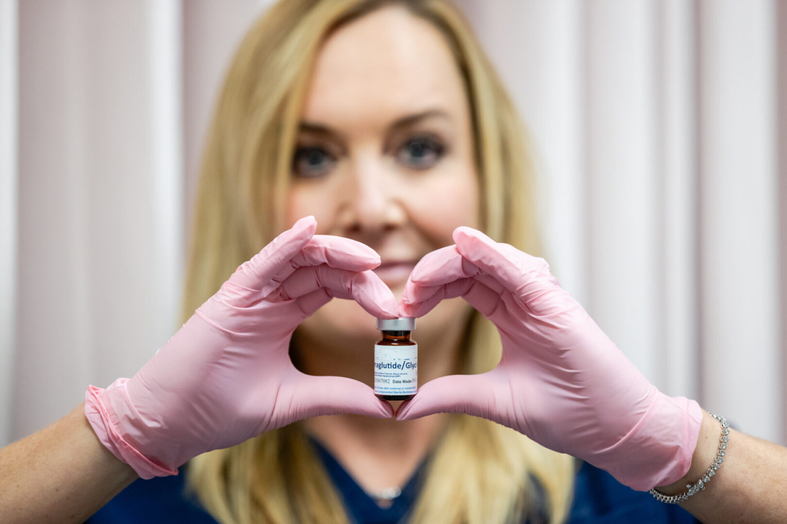 A woman holding up a small bottle of medicine.