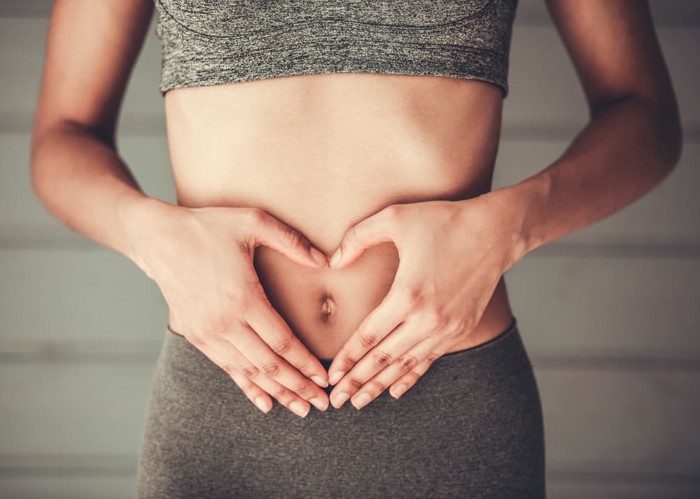 body Woman's hands forming heart on abdomen.